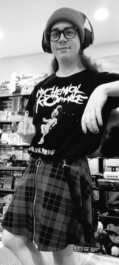 A greyscale photo of a derp-faced kidult giving a middle finger while sloppily dressed